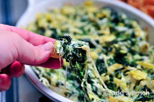 Spinach Artichoke Dip being dipped onto a chip.