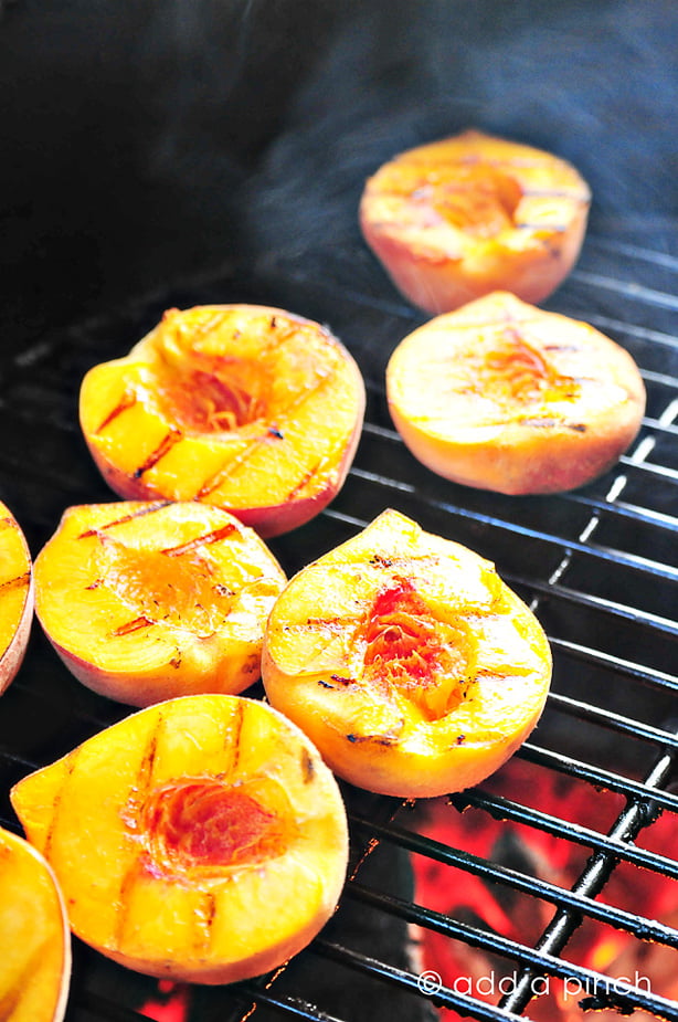Hot grill with peaches being grilled