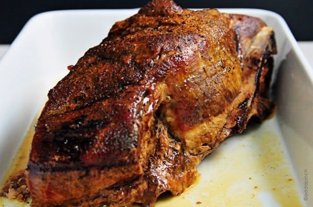 Photograph of cooked pork roast in a white baking dish.