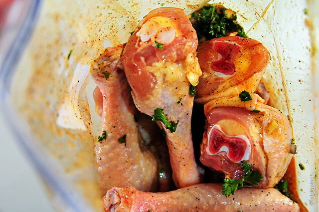 View inside a plastic zip bag with chicken legs in marinade  // addapinch.com