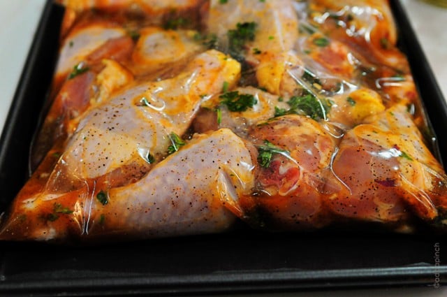 Baking pan holds plastic bag with chicken and marinade // addapinch.com