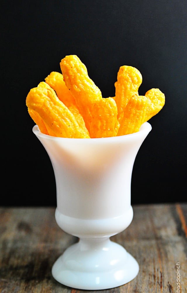 Fluted Cheese Straws stood on end in a white milk glass vessel