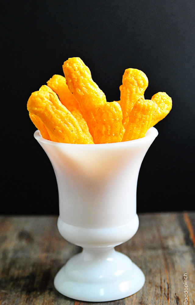 Fluted Cheese Straws stood on end in a white milk glass vessel