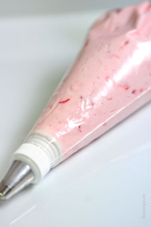 Bag of Strawberry Buttercream frosting with frosting tip. 