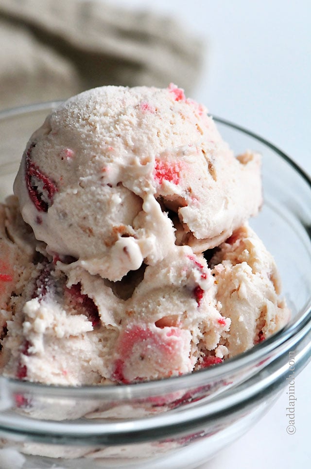 Glass bowl full of strawberry ice cream loaded with fresh strawberries // addapinch.com