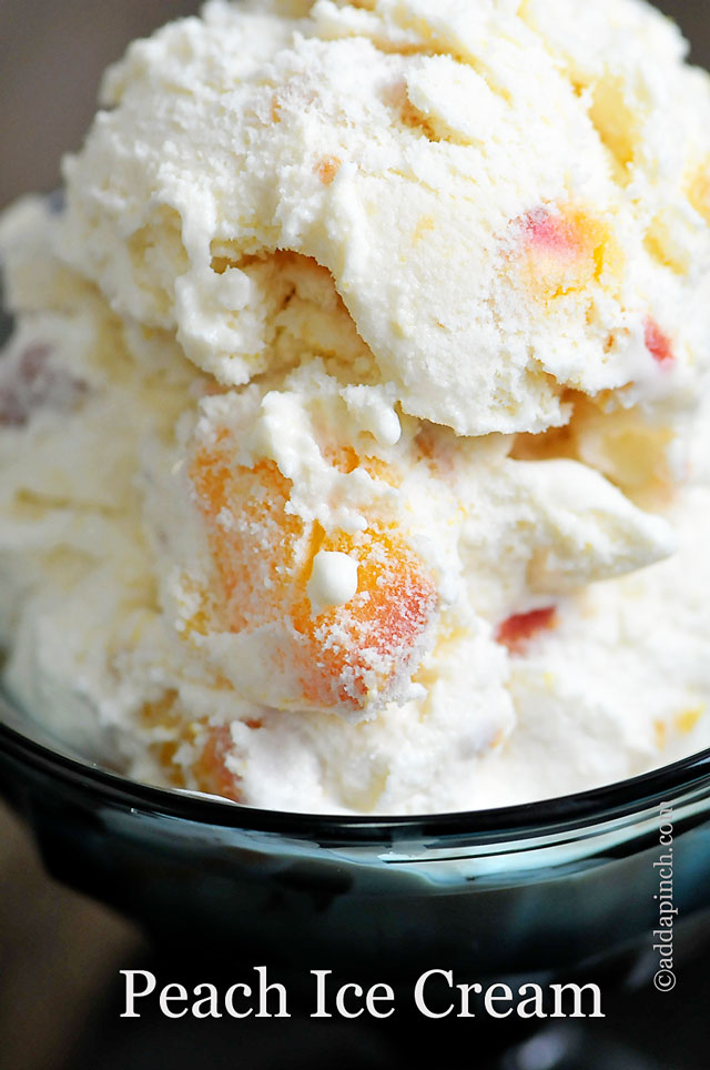 Peaches are throughout this closeup picture of ice cream in a glass dish - ©addapinch.com