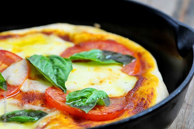 Margherita pizza inside a cast iron skillet. 