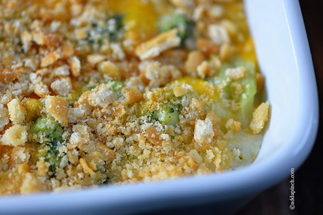 Corner of casserole dish full of Broccoli Cheese Casserole - addapinch.com