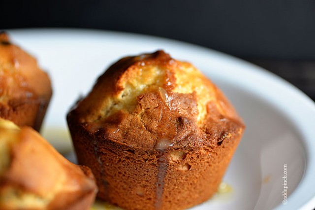 Cranberry Orange Muffins on white plate with orange glaze.