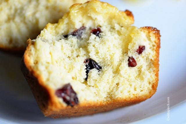 Cranberry Orange Muffins sliced in half so that juicy cranberries are seen inside.