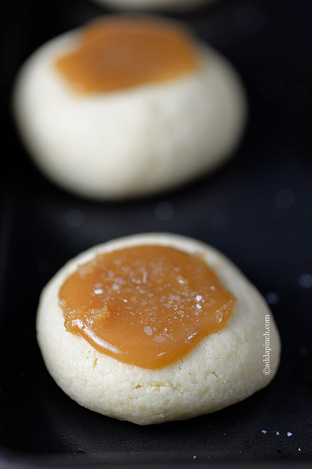 Soft golden cookies with a thumbprint indention in the center holds a spoonful of salted caramel. 