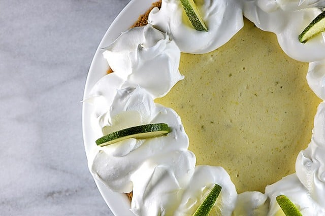 Key Lime Pie with dollops of whipped cream and lime slices.