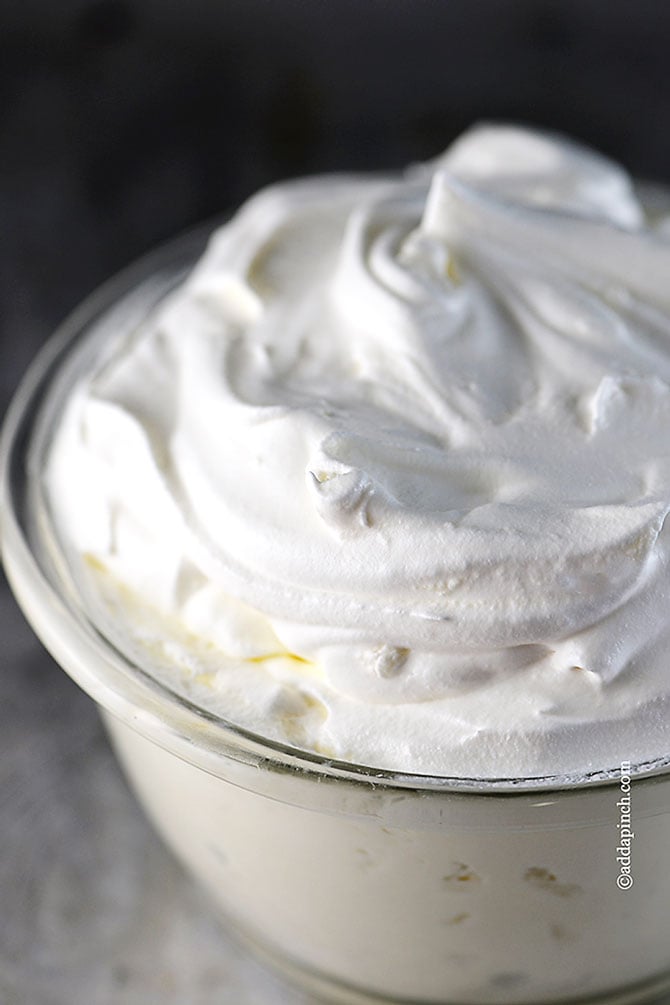 Glass bowl full of fluffy, Perfect Whipped Cream //addapinch.com