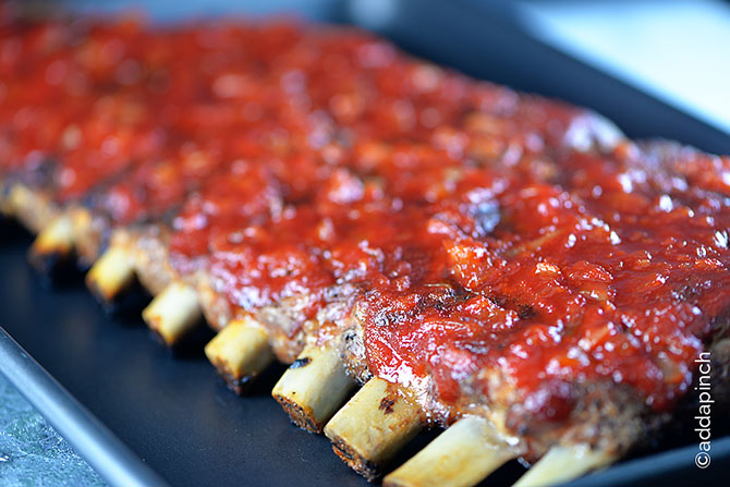 Rack of BBQ Ribs on a baking sheet from addapinch.com