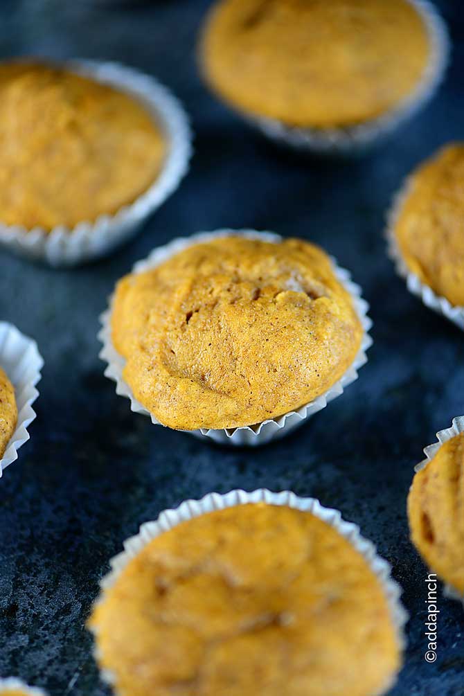 Fresh Pumpkin Muffins in paper muffin liners on a granite counter.  