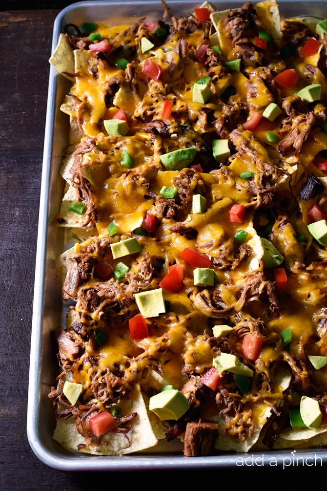 Brisket Nachos make a quick and easy way to repurpose leftover brisket. So simple and so delicious, it will become a favorite! // addapinch.com