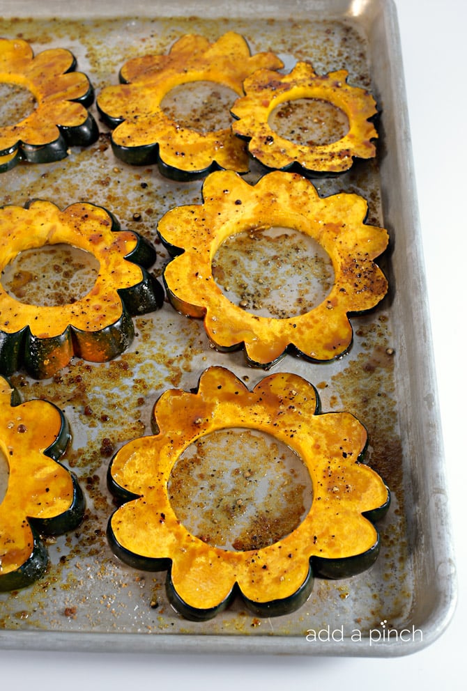 Maple Roasted Acorn Squash Recipe - Maple Roasted Acorn Squash makes a quick, delicious, and beautiful side dish. Made of acorn squash, maple syrup, and a sprinkling of spices. // addapinch.com