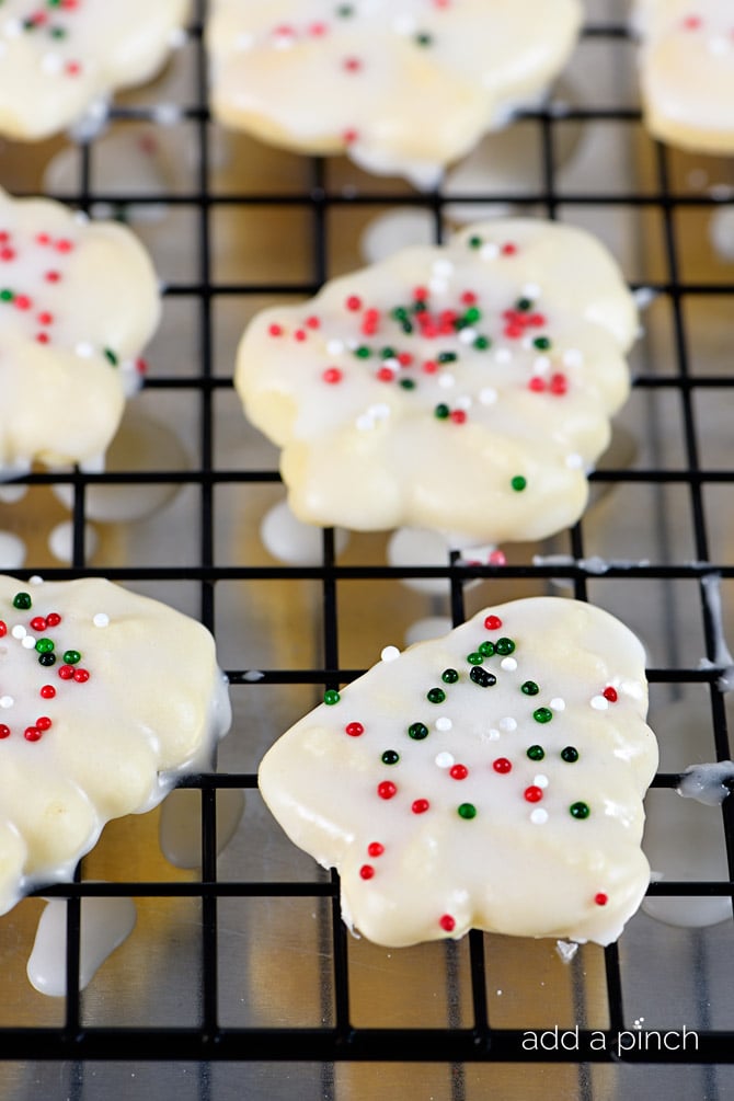 Cooling rack with freshly glazed Spritz cookies with sprinkles on top