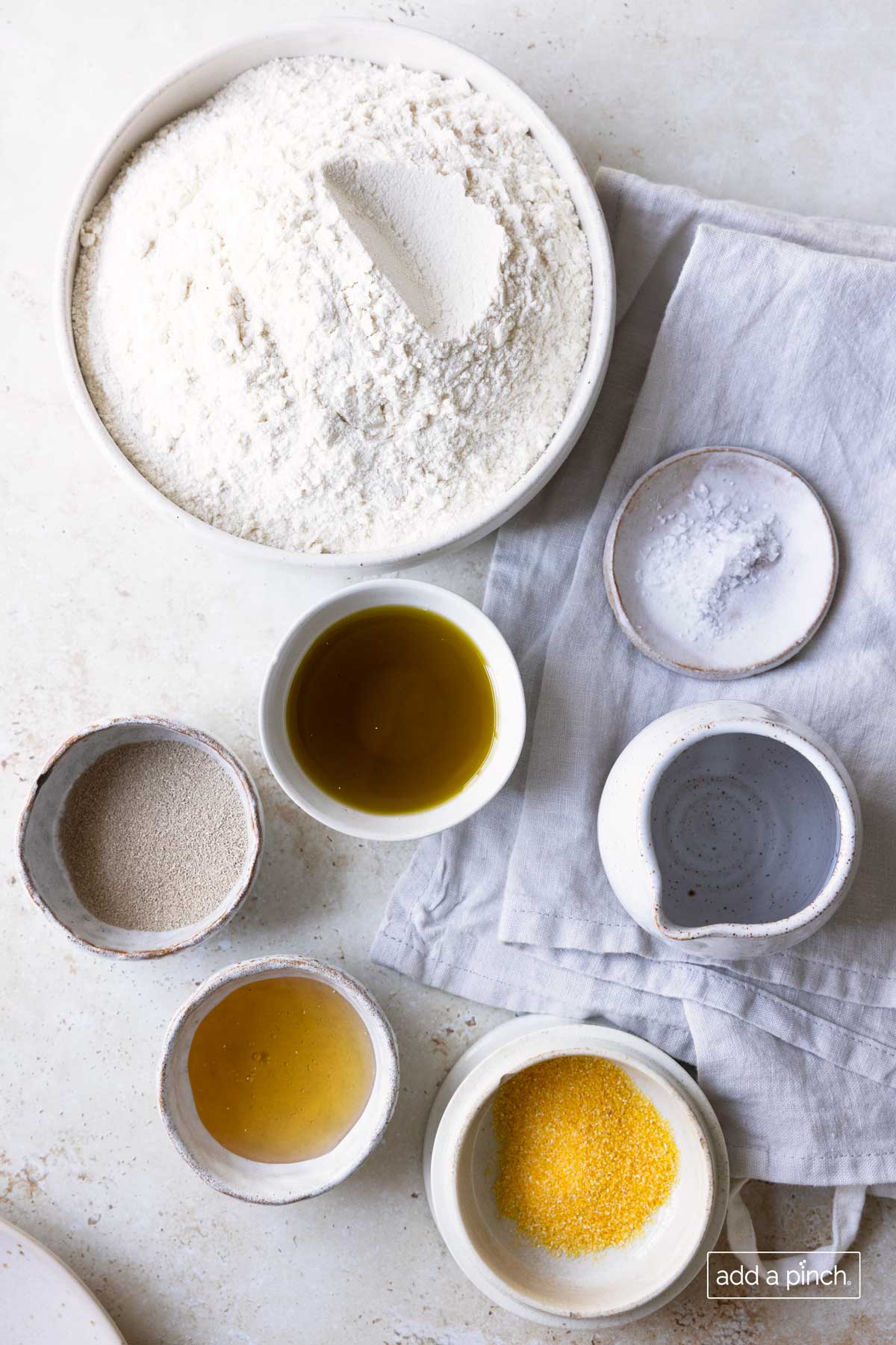 Photo of ingredients used to make pizza dough and the extra ingredient we use to help the dough from sticking to the pizza peel or pizza stone.