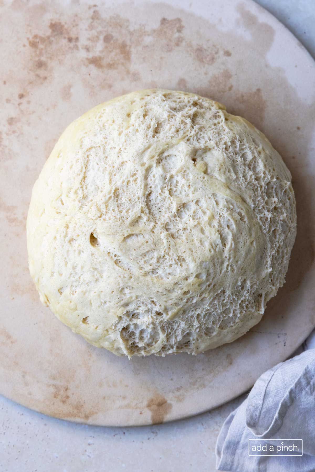 Pizza dough in a ball on a pizza board is ready to be used.