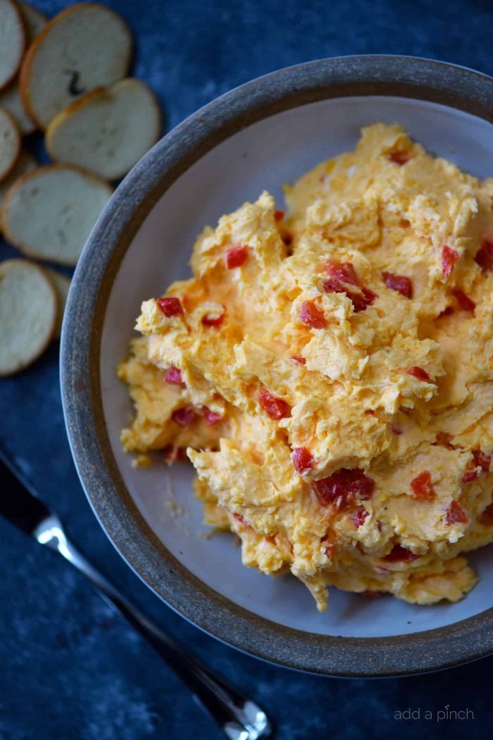 A plate with a scoop of pimento cheese and bagel chips. 