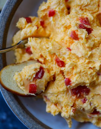 Southern Pimento Cheese Recipe - A staple spread in Southern home and parties, pimento cheese is a classic! Made with cheddar cheese, pimentos and a secret ingredient, this pimento cheese recipe is always a hit! // addapinch.com