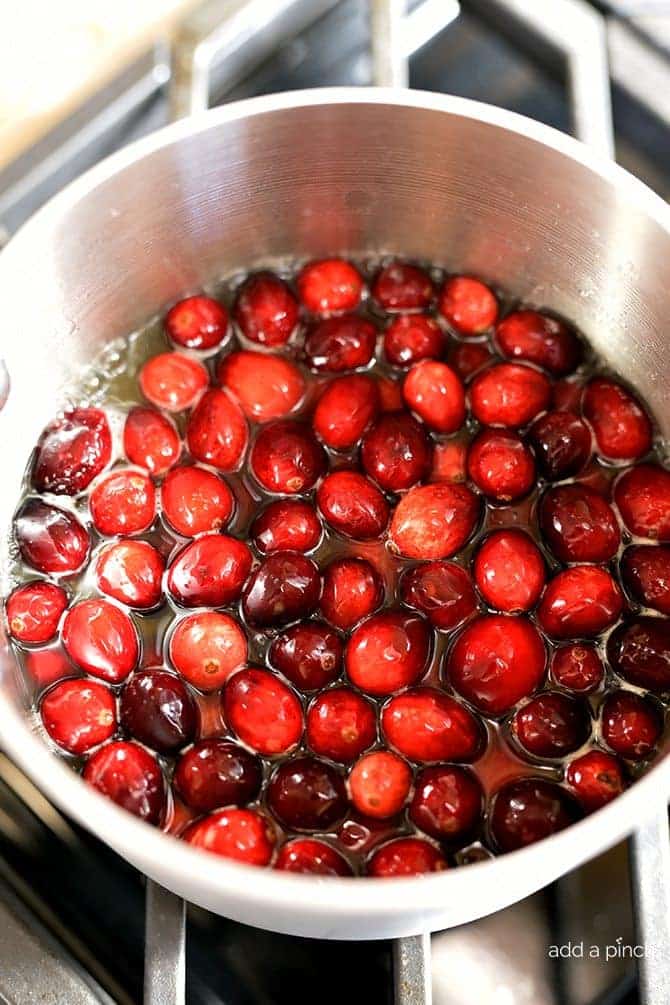 Cranberries have been added to pot of water and orange juice to cook.