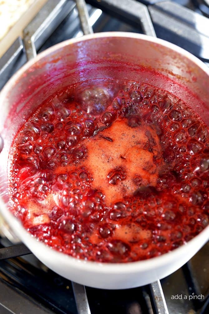 Classic Cranberry Sauce Cooking in Saucepan - Cranberries pop open as ingredients boil. // addapinch.com