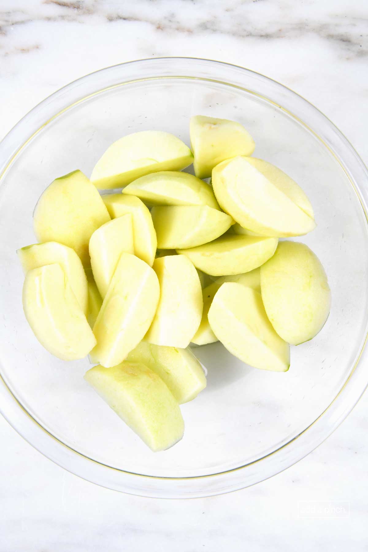 Apple slices in a glass bowl. 