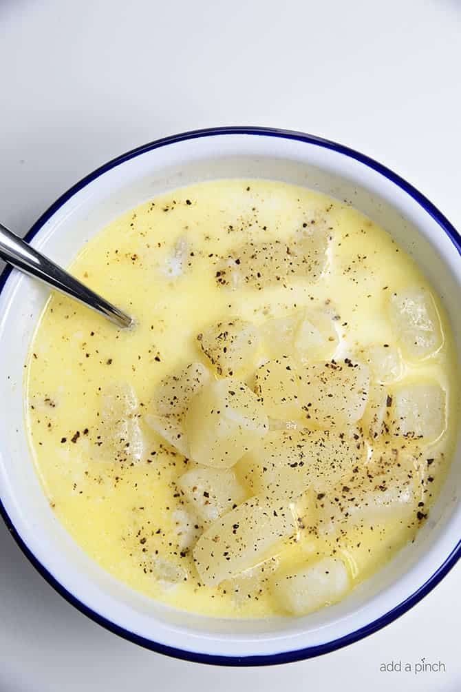 Bowl of Potato Soup seasoned with black pepper // addapinch.com