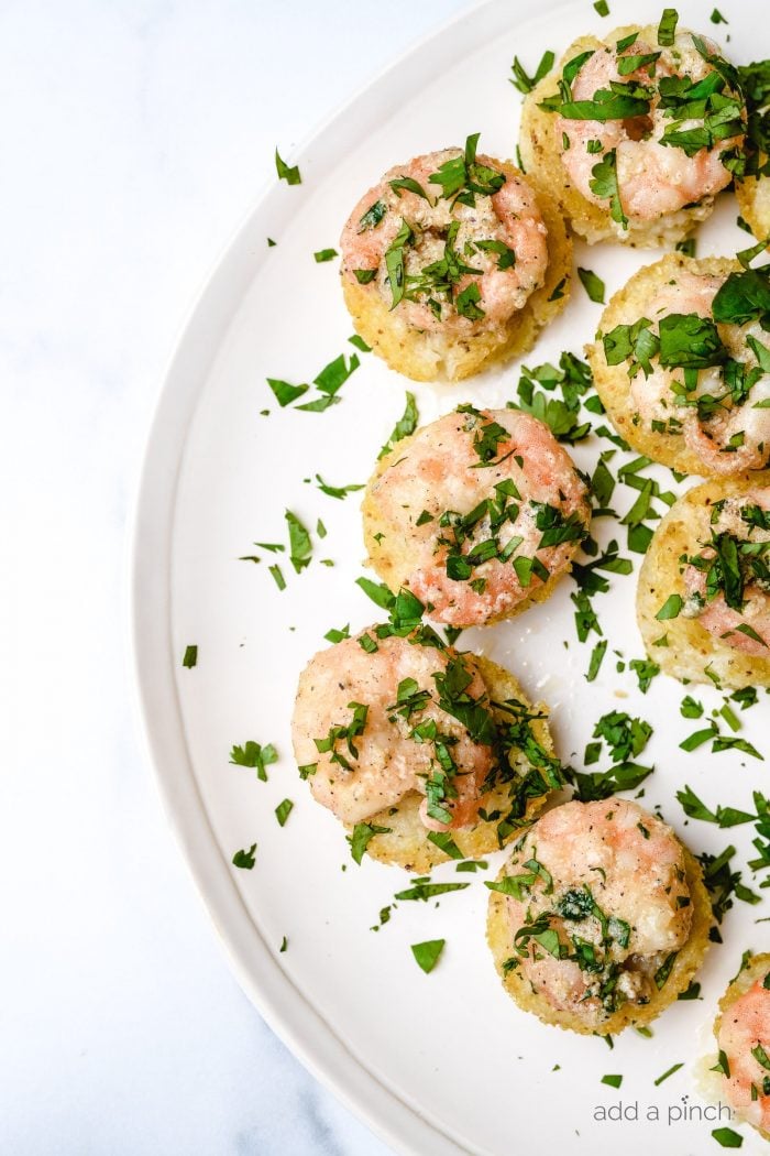 Shrimp top baked grits on a plate. Garnished with fresh parsley // addapinch.com