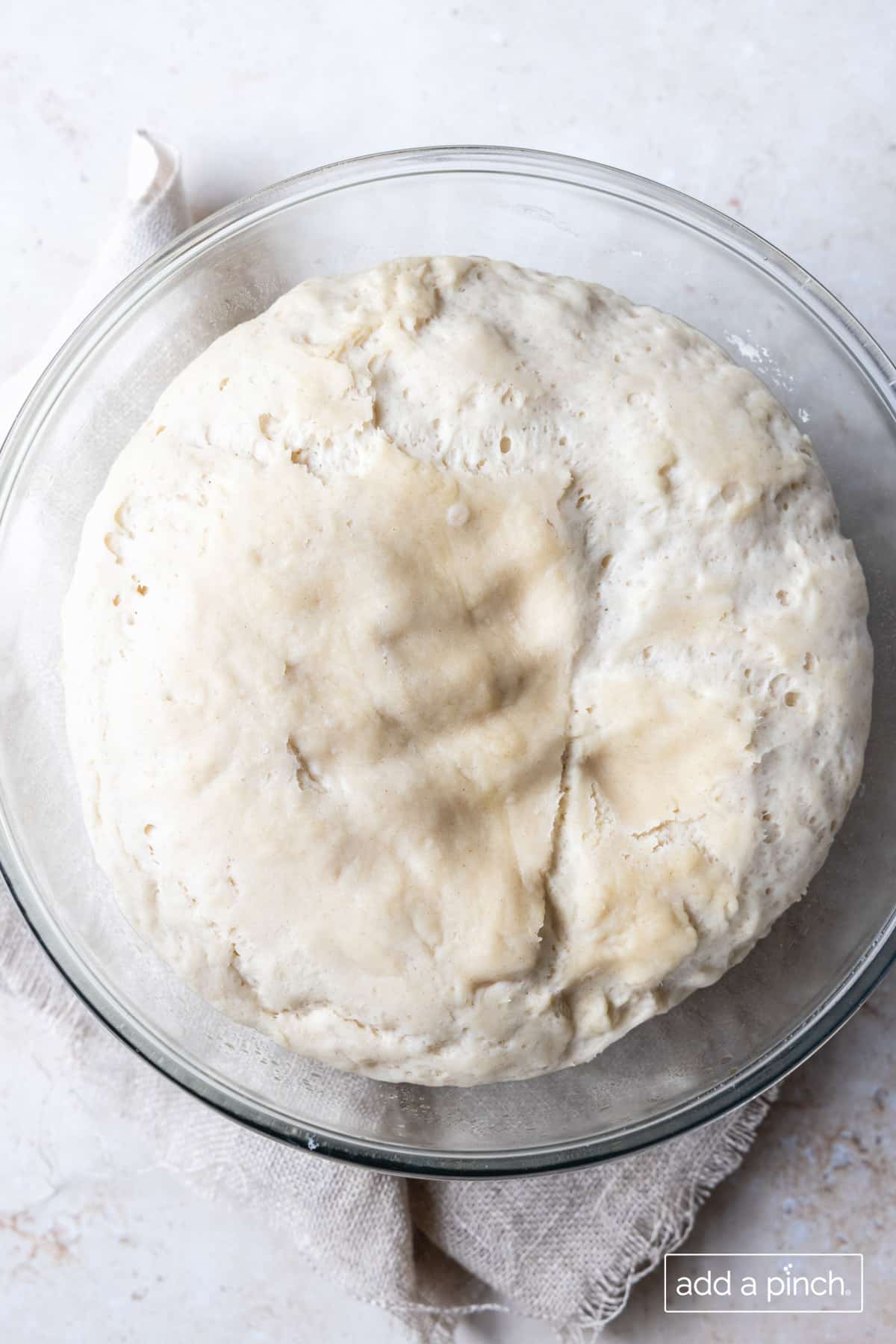 photo of calzone dough in a glass bowl.