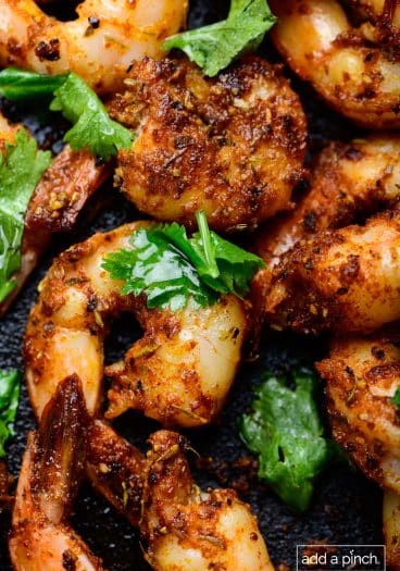 Photo of blackened shrimp in a cast iron skillet.