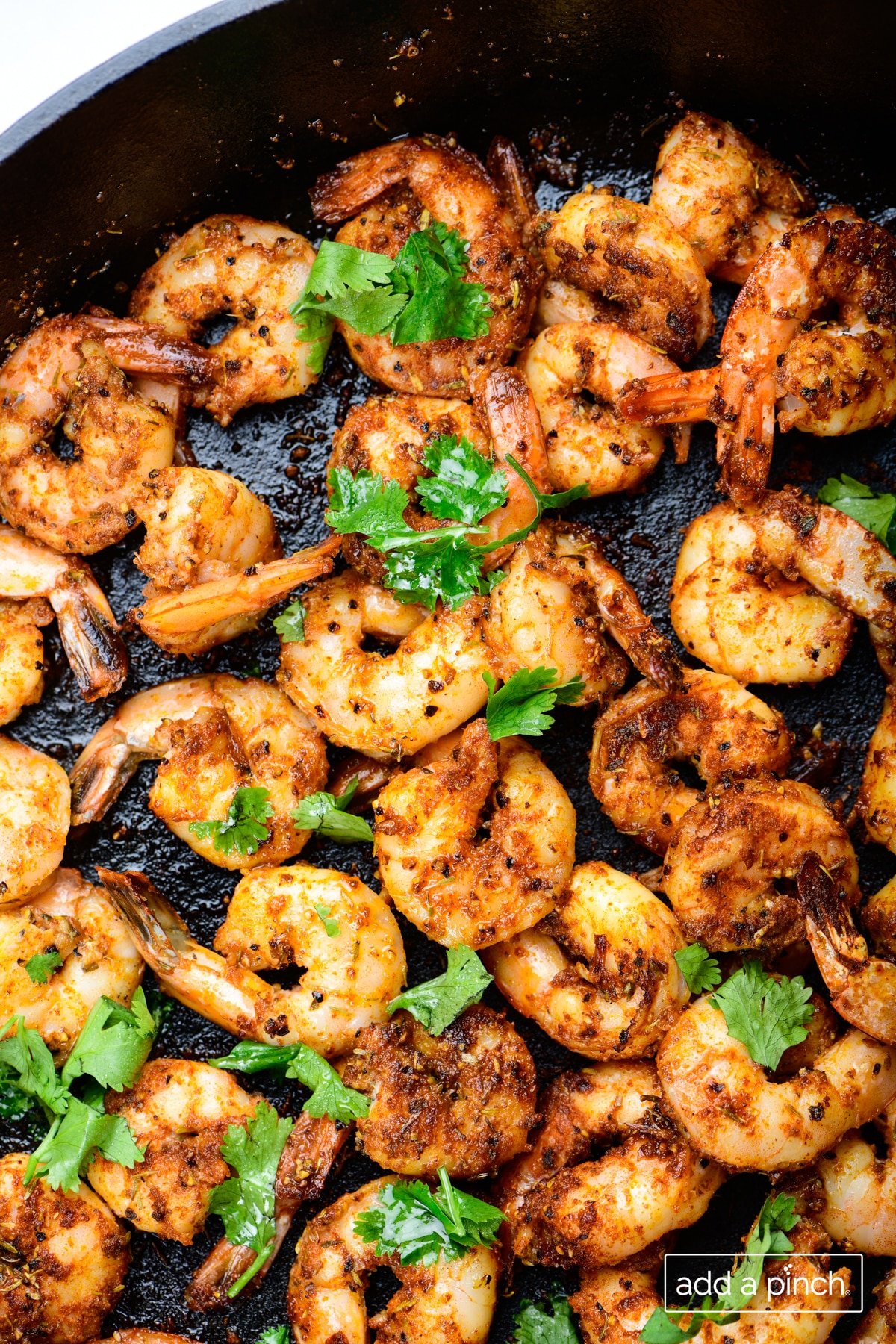 Photo of blackened shrimp in a skillet with cilantro.