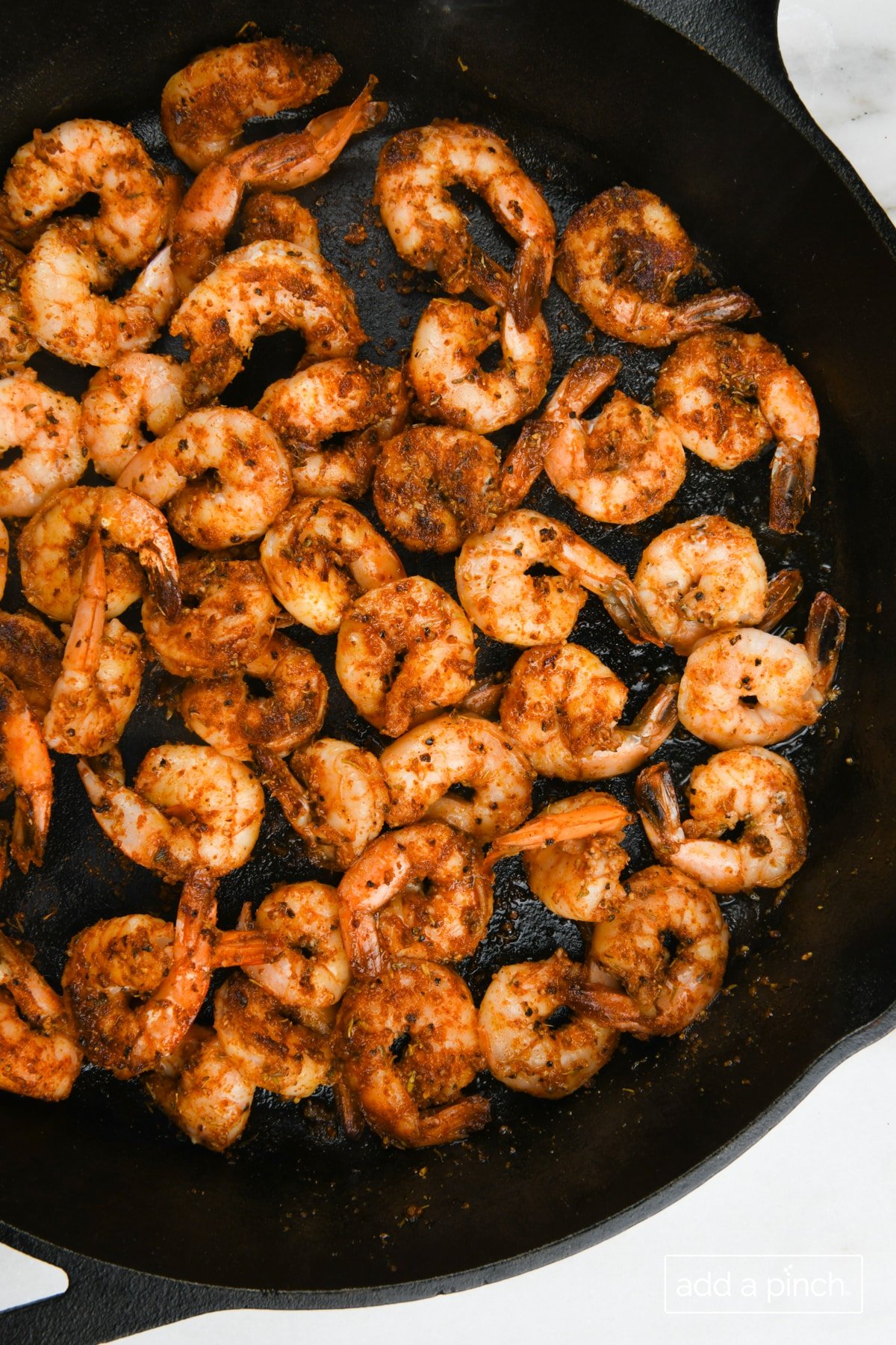 Cooked blackened shrimp in a cast iron skillet.