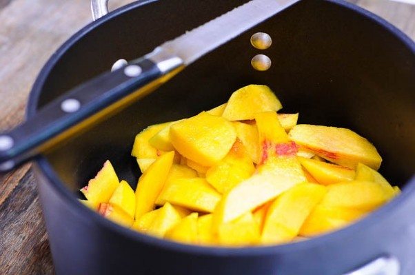 Saucepan full of sliced peaches.