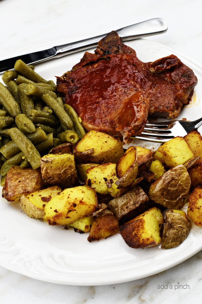 Slow Cooker BBQ Pork Chops - The slow cooker makes these pork chops fork tender and a family favorite! Just 5 minutes of prep time make this a favorite weeknight meal! // addapinch.com