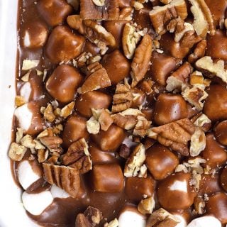 Cake with pecans, marshmallows and chocolate with a chocolate icing in a white cake pan // addapinch.com