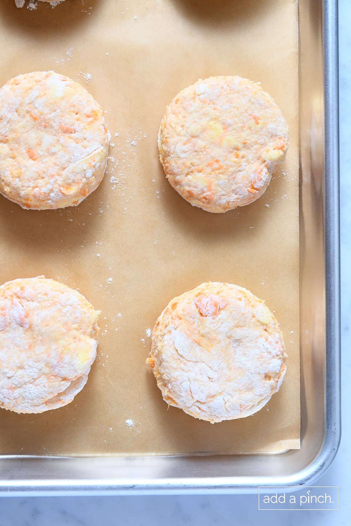 Sweet potato biscuits on a parchment lined baking sheet.
