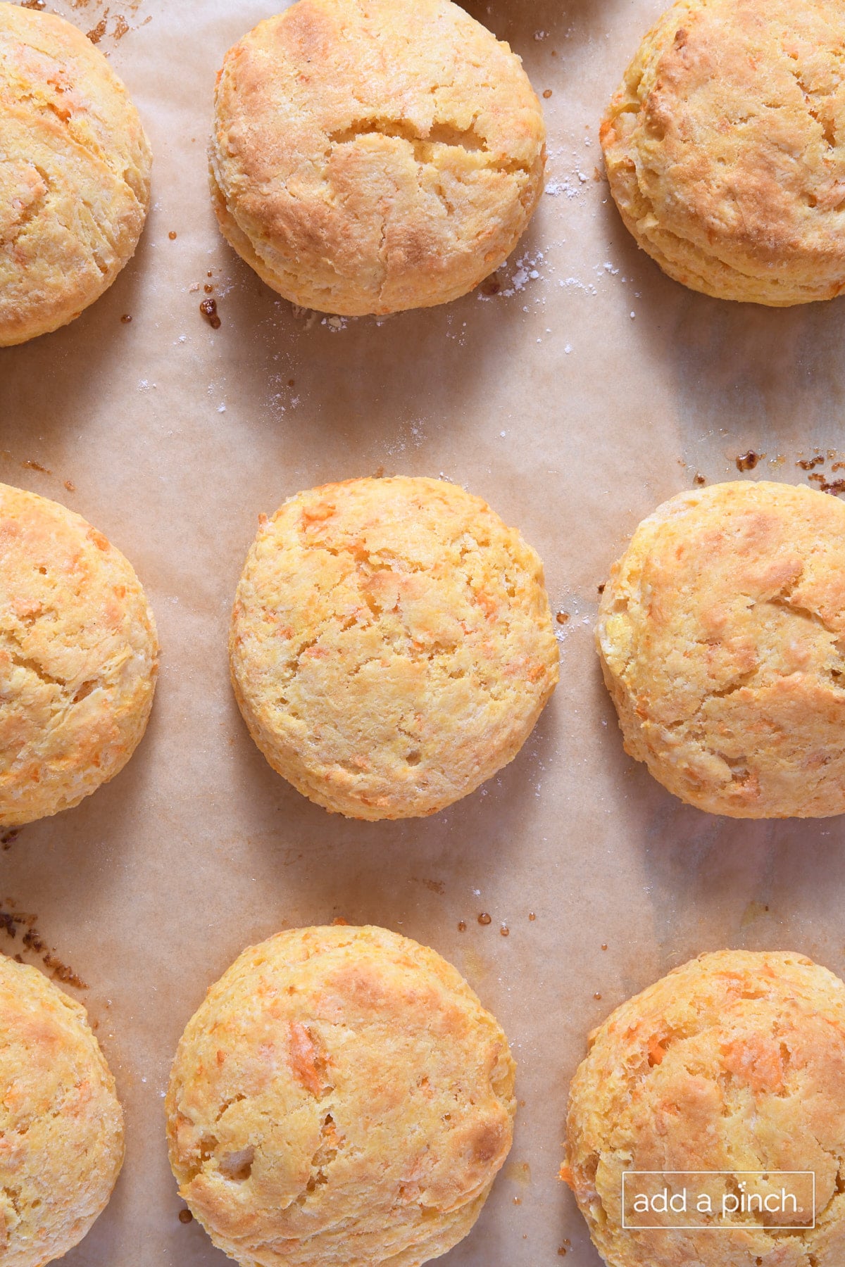 Baked sweet potato biscuits on a parchment paper lined baking sheet.