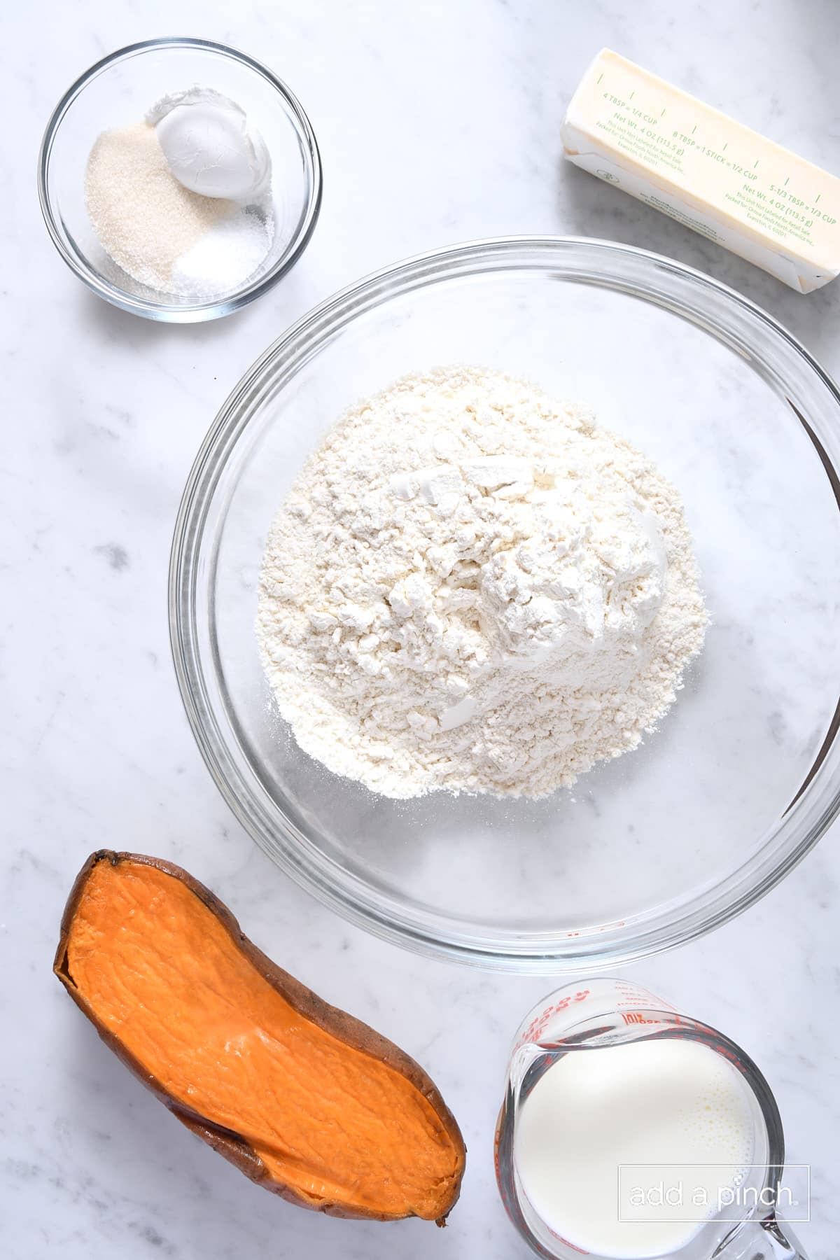 Ingredients to make sweet potato biscuits on a marble surface.