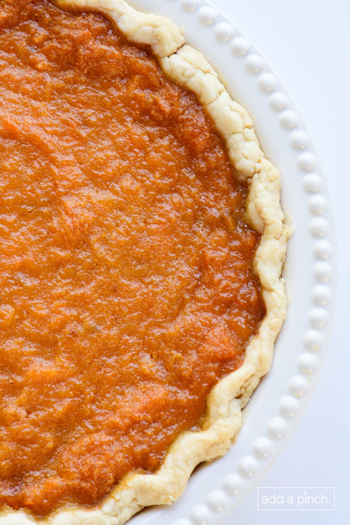 Overhead photograph of sweet potato pie in a homemade pie crust in white pie plate.