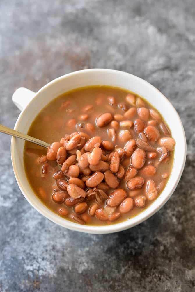 Pinto Beans with spoon in a white bowl. 