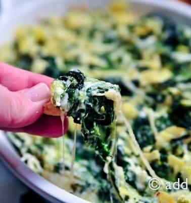 Cheesy Spinach Artichoke Dip dipped onto a chip // addapinch.com