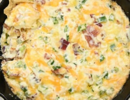 Jalapeno Popper Dip in a skillet with a tortilla chip