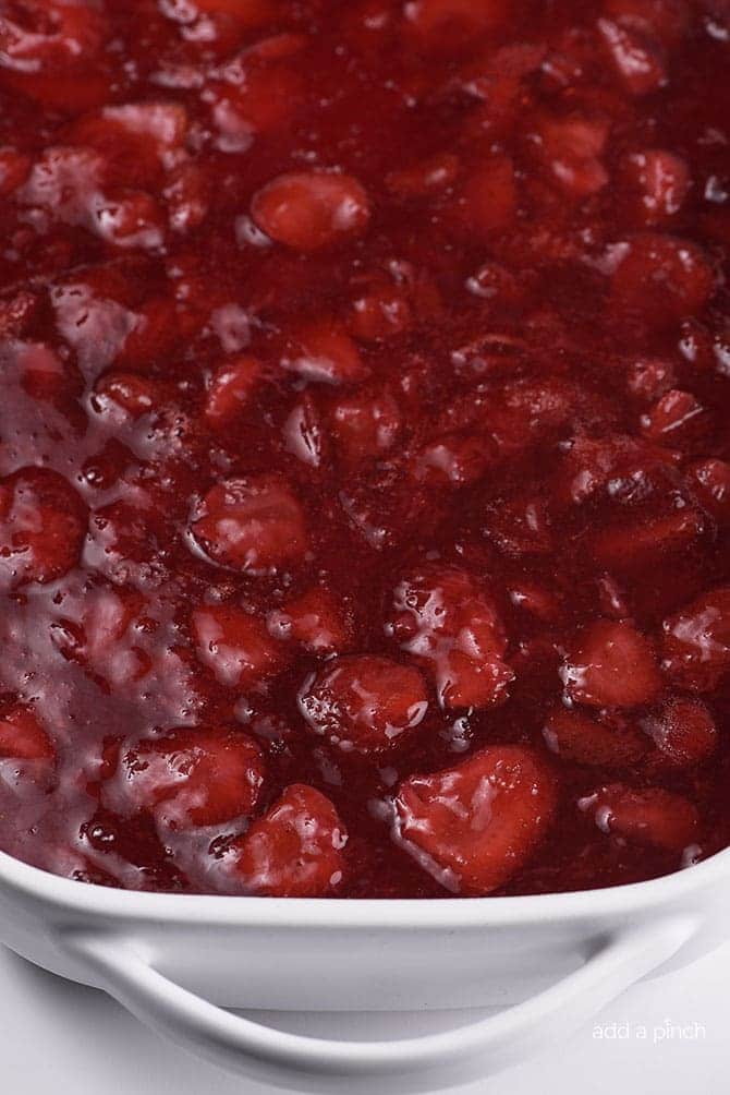 Top layer of Strawberry Pretzel Salad in white baking dish  // addapinch.com