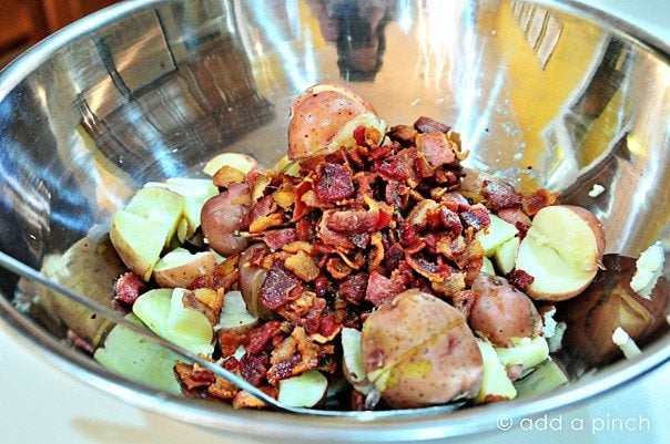 Stainless bowl with tender potatoes, crispy bacon to make Warm Potato Salad with Bacon
