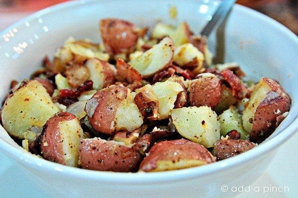 Bowl of warm potato salad with warm bacon dressing poured over.