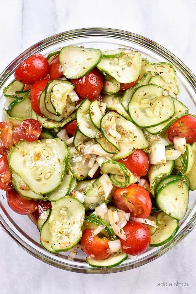 Cucumber Tomato Salad Recipe - A quick and easy summer staple, this cucumber and tomato salad goes well with fish, chicken, pork, or a plate filled with veggies! Add in onions too if you like! // addapinch.com
