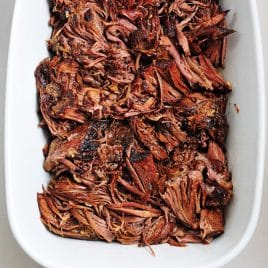 Balsamic pot roast in a white serving dish.